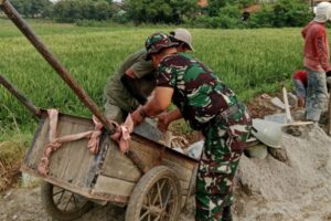 Pra TMMD Ke 120 Kodim 0510/Trs, Semangat Personil TNI Gunakan Gerobak Kayu Angkut Batu Koral