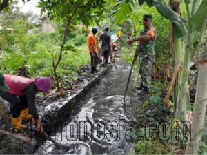 Babinsa Koramil 11/Pebayuran bersama warga membersihkan saluran air dalam kerja bakti gotong royong.