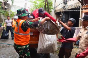 Personel TNI Kodim 0506/Tgr membantu warga mengangkut sampah pasca banjir di Tangerang.