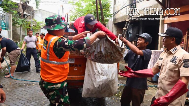 Personel TNI Kodim 0506/Tgr membantu warga mengangkut sampah pasca banjir di Tangerang.