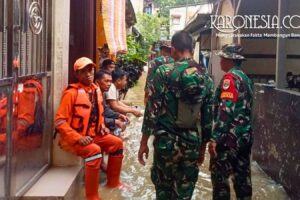 Personel TNI Babinsa dan petugas BPBD berbaju oranye sedang memantau kondisi banjir di pemukiman warga Bidara Cina Jakarta Timur.