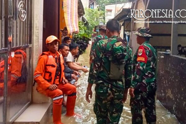 Personel TNI Babinsa dan petugas BPBD berbaju oranye sedang memantau kondisi banjir di pemukiman warga Bidara Cina Jakarta Timur.
