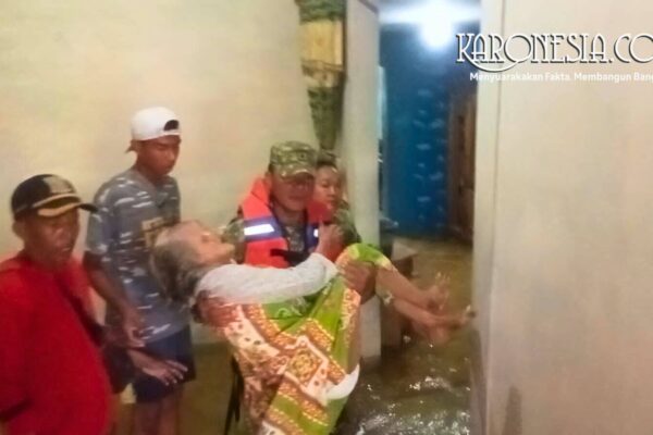 Anggota Babinsa mengevakuasi lansia di tengah banjir Bekasi.