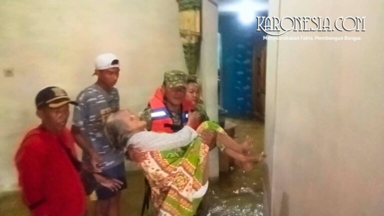 Anggota Babinsa mengevakuasi lansia di tengah banjir Bekasi.