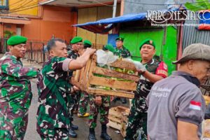 Anggota Babinsa Kodim 0506 Tangerang evakuasi wadah sampah.