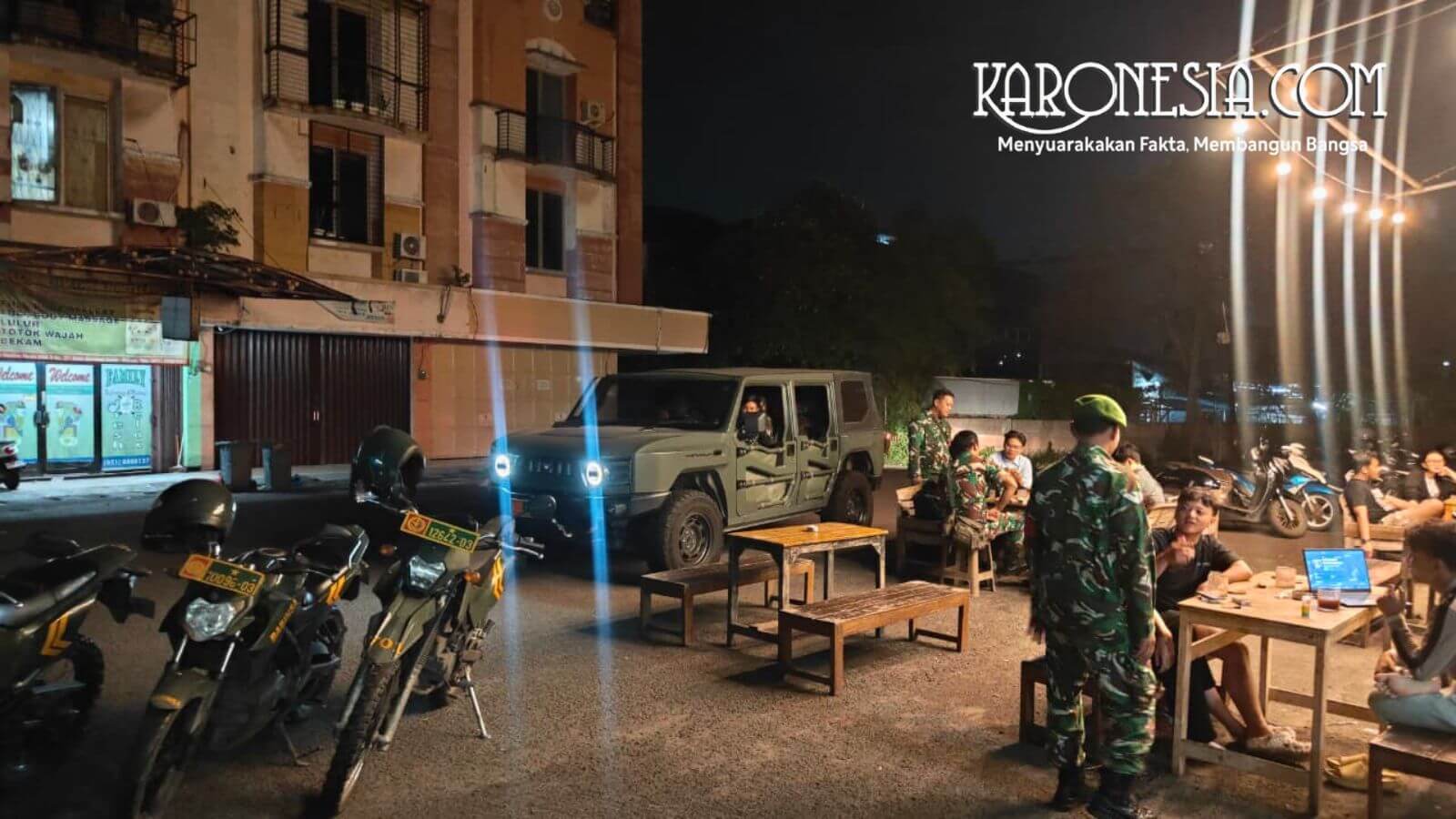 Babinsa Koramil Kranji menyapa warga saat patroli malam menggunakan kendaraan Maung dan motor dinas di Bekasi.