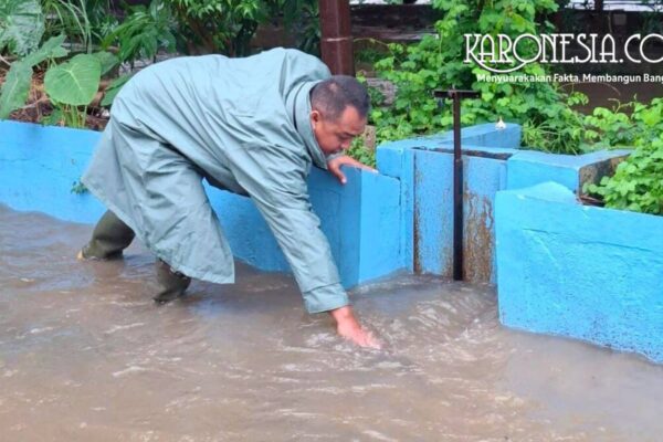 Babinsa Margahayu membersihkan sumbatan sampah di pintu air saat banjir melanda Bekasi Timur.
