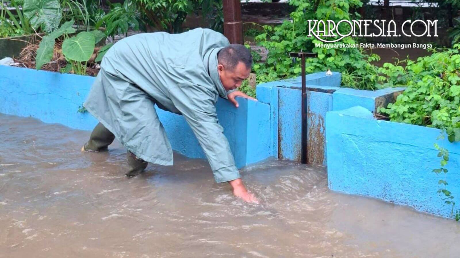 Babinsa Margahayu membersihkan sumbatan sampah di pintu air saat banjir melanda Bekasi Timur.