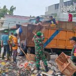 Personel TNI Koramil 01 Tangerang bersama warga gotong royong mengangkut tumpukan sampah ke dalam truk di Karawaci.
