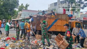 Personel TNI Koramil 01 Tangerang bersama warga gotong royong mengangkut tumpukan sampah ke dalam truk di Karawaci.