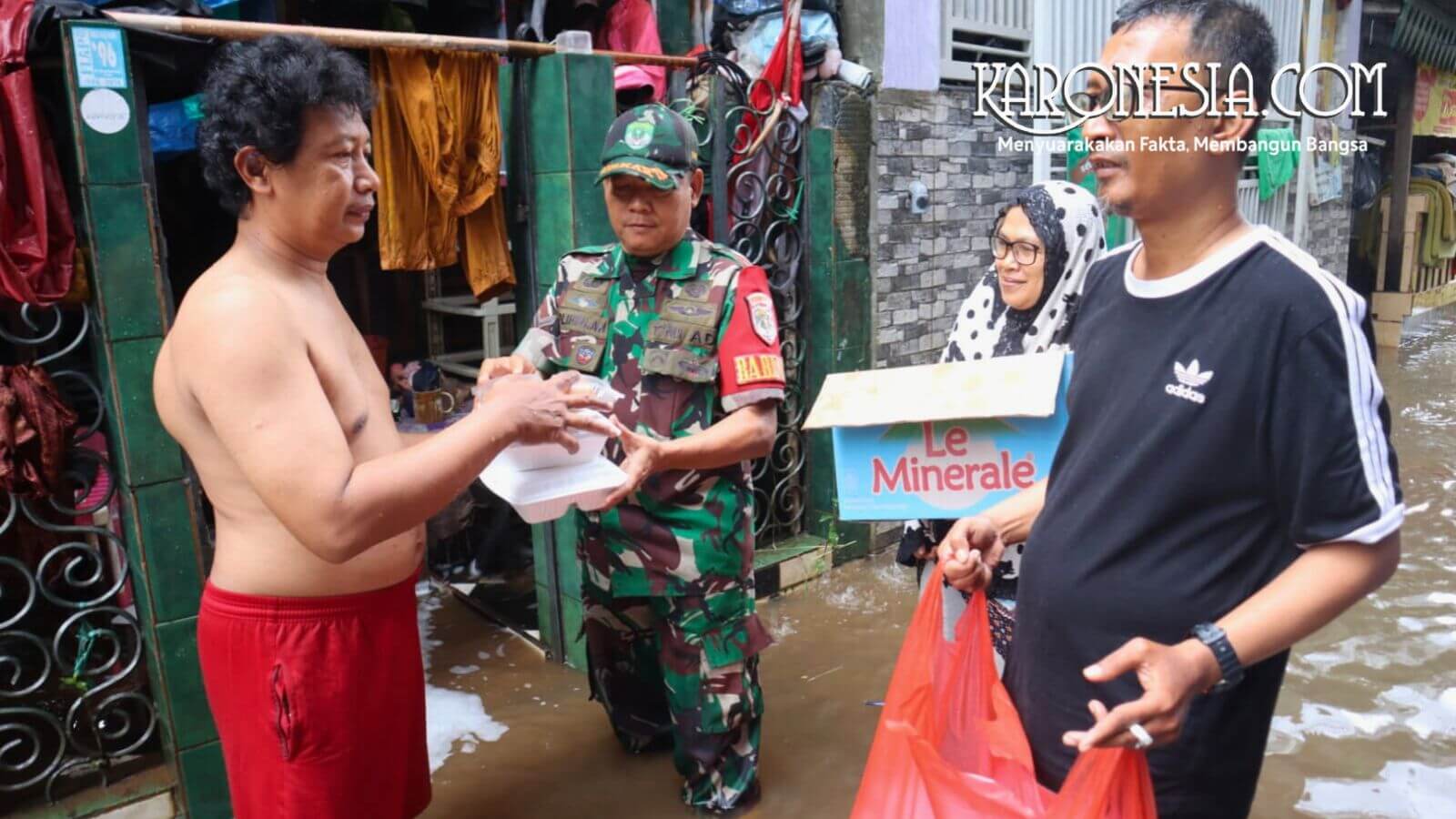 Babinsa Koramil 05 Kebayoran Baru memberikan bantuan makanan kepada warga korban banjir Petogogan Jakarta Selatan.