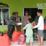 Personel TNI menyalurkan bantuan makanan siap saji kepada warga terdampak banjir di Sepatan Tangerang.