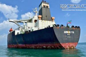 Kapal Tanker MT Arman 114 berwarna hitam dan merah tampak mengapung di perairan tenang di bawah langit biru