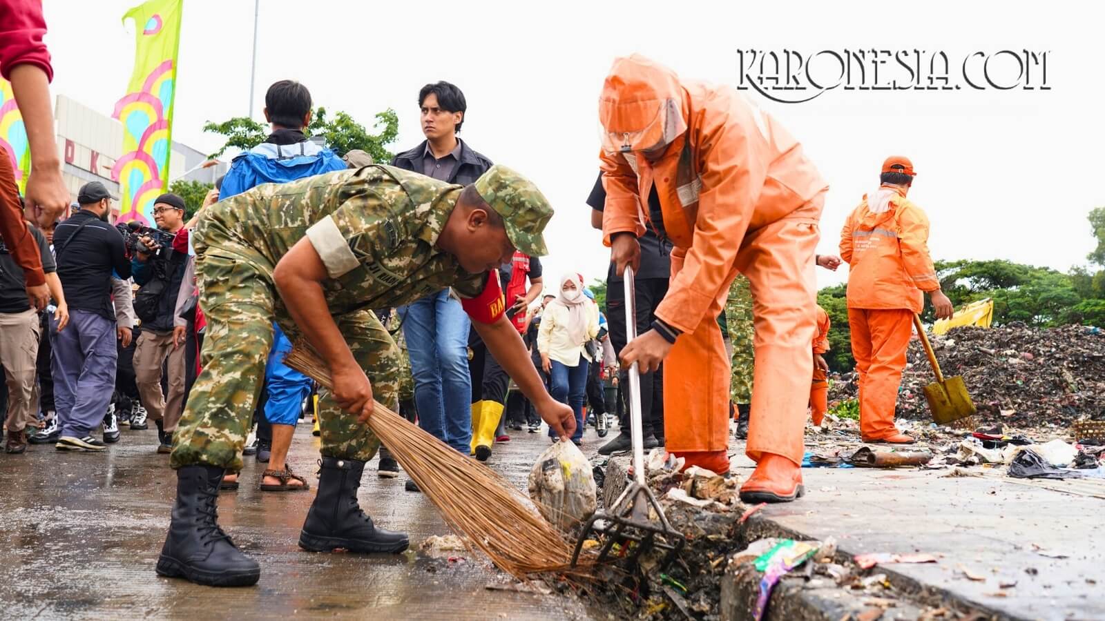 Anggota TNI bersama petugas kebersihan mengangkut sampah dari saluran jalan saat kerja bakti serentak Jaga Jakarta Bersih di Jakarta Utara.