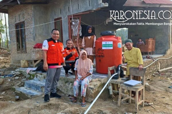 Relawan Baznas Tangsel bersama warga di depan rumah bantuan dan tangki air bersih korban banjir Aceh Tamiang