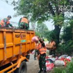 Anggota Koramil Pasar Kemis membersihkan sampah di lingkungan desa