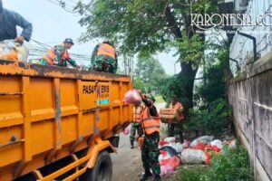 Anggota Koramil Pasar Kemis membersihkan sampah di lingkungan desa