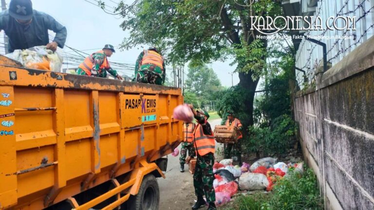 Anggota Koramil Pasar Kemis membersihkan sampah di lingkungan desa