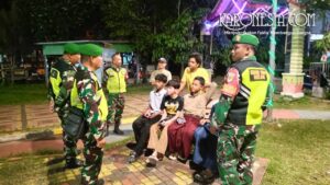 Personel Koramil 03 Teluk Pucung berdialog dengan warga saat patroli humanis malam di taman Kota Bekasi