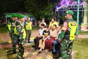 Personel Koramil 03 Teluk Pucung berdialog dengan warga saat patroli humanis malam di taman Kota Bekasi