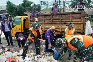 Personel TNI Koramil Cisoka bersama warga mengangkut sampah di Jalan Raya Serang Desa Cikande Kabupaten Tangerang