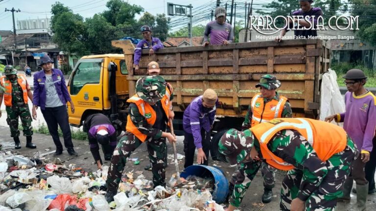 Personel TNI Koramil Cisoka bersama warga mengangkut sampah di Jalan Raya Serang Desa Cikande Kabupaten Tangerang