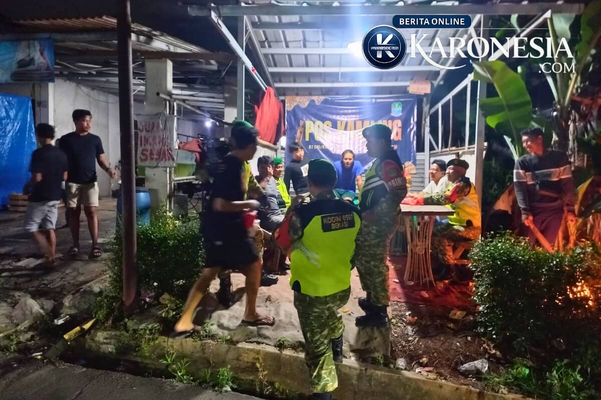 Personel Kodim 0507 Bekasi melakukan patroli jalan kaki di pos kamling wilayah Jati Asih pada malam hari