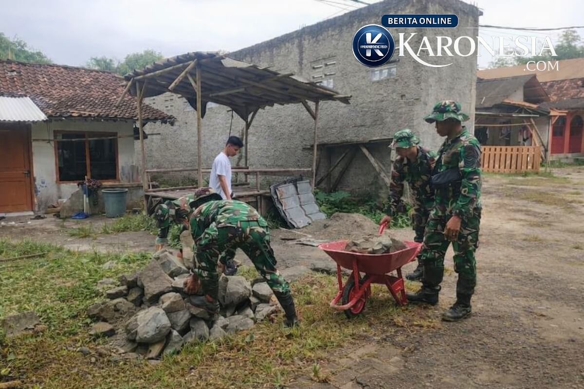 Anggota TNI memindahkan batu untuk pembangunan