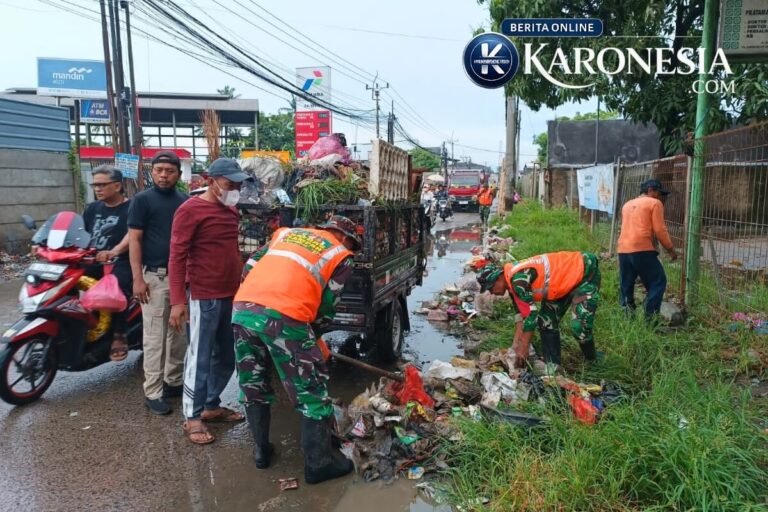 Personel TNI dan petugas membersihkan sampah di pinggir jalan