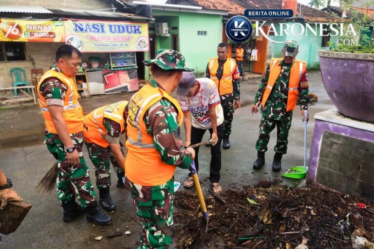 Personil Satgas Sampah Kodim Tigaraksa membersihkan tumpukan sampah bersama warga.