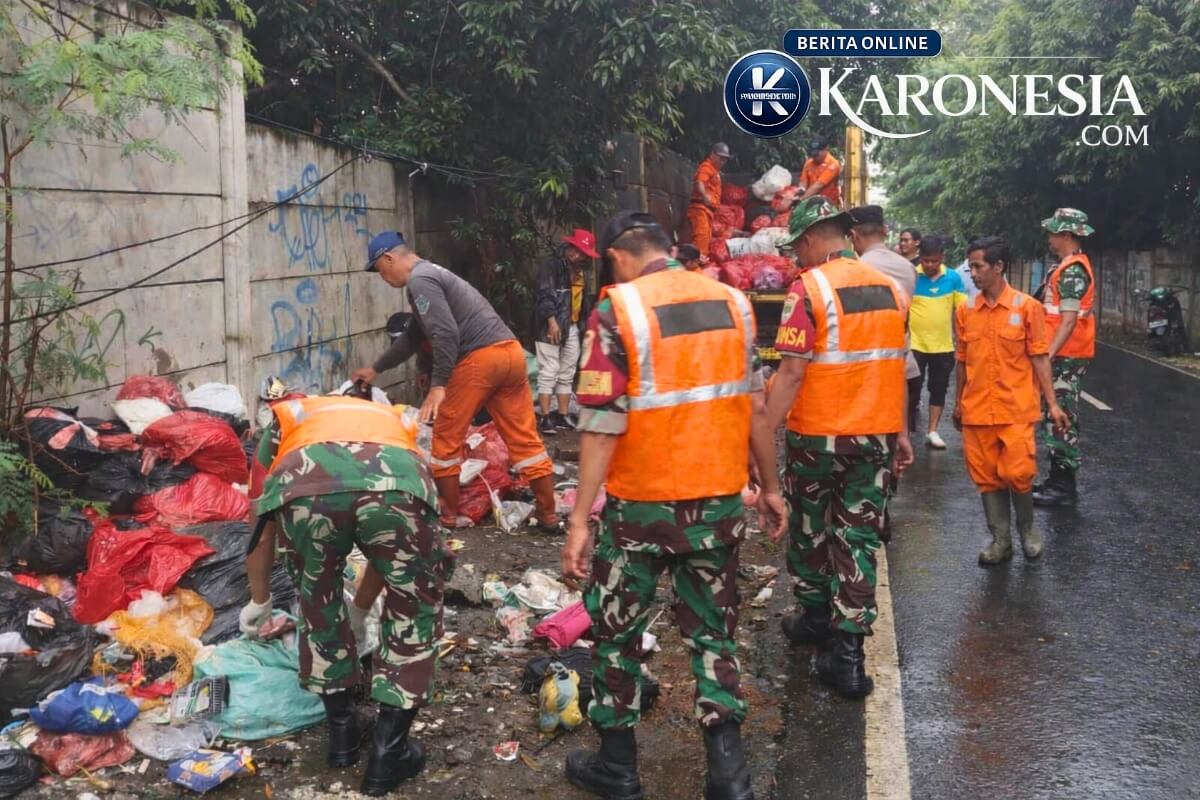 Personel TNI dan petugas DLH berseragam oranye membersihkan tumpukan sampah di Jalan Lio, Parigi Baru, Pondok Aren, Tangerang Selatan.