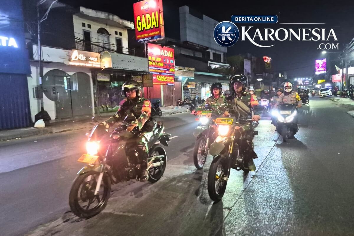 Babinsa Koramil 02/Pondok Gede melakukan patroli malam menggunakan sepeda motor di jalanan Kota Bekasi.