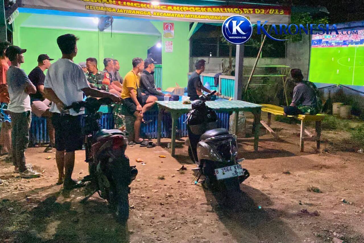 Babinsa dan warga Jatiranggon nonton bareng Piala Dunia di poskamling malam hari.
