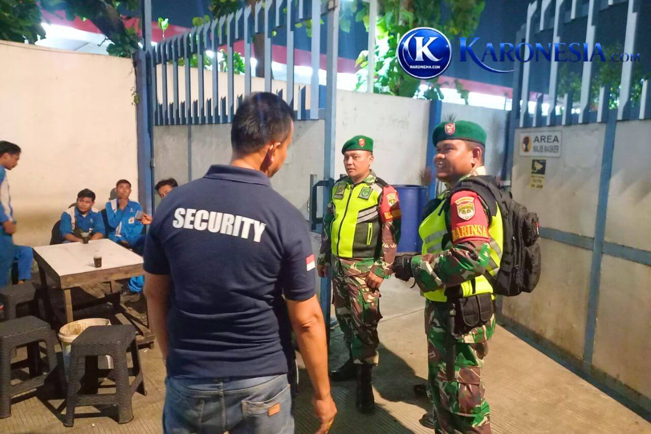 Personel Babinsa Koramil Jati Asih berdialog dengan petugas keamanan saat patroli malam.