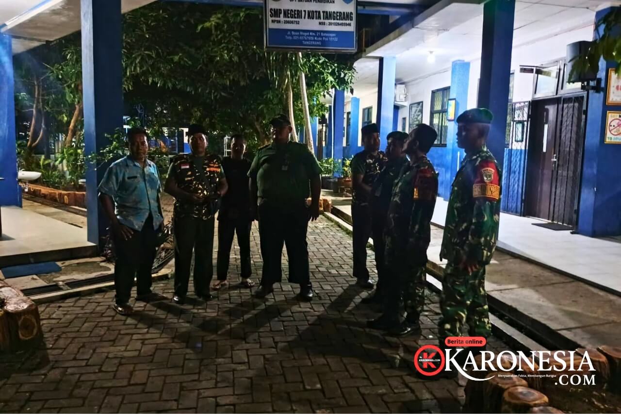Personel TNI dan warga berdiri bersama saat patroli malam di Tangerang
