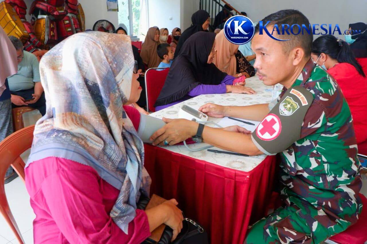 Personel TNI memeriksa tekanan darah warga saat bakti kesehatan di Mustika Jaya.