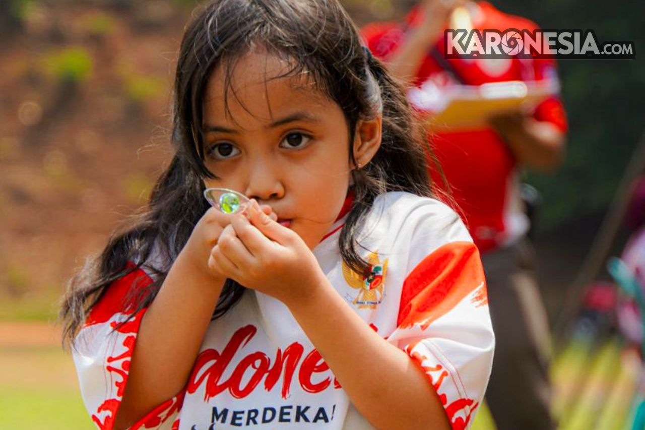 Anak perempuan peserta lomba lari kelereng mengenakan kaos merah putih pada perayaan HUT ke-81 RI di Kompleks Batalyon Arhanud 10/ABC.