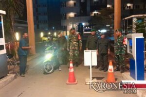 Babinsa bersama warga melakukan patroli malam menjaga keamanan lingkungan.