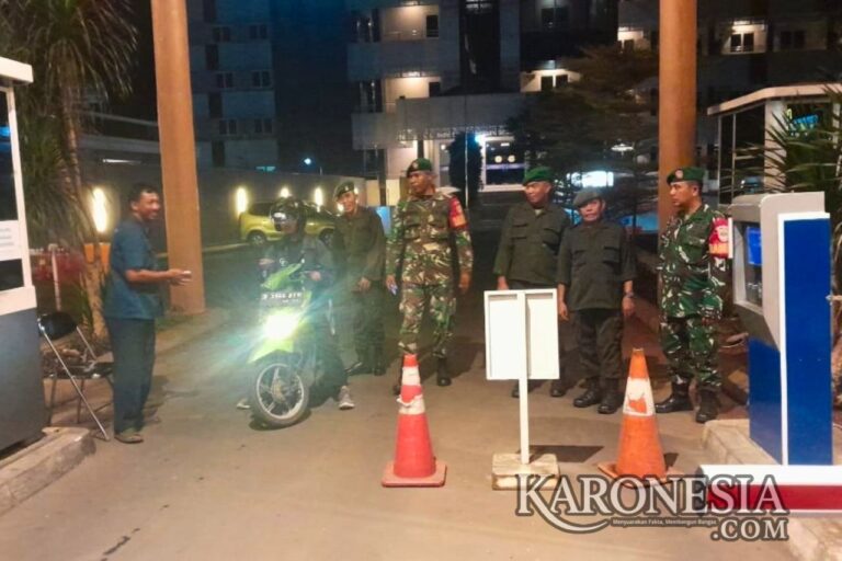 Babinsa bersama warga melakukan patroli malam menjaga keamanan lingkungan.