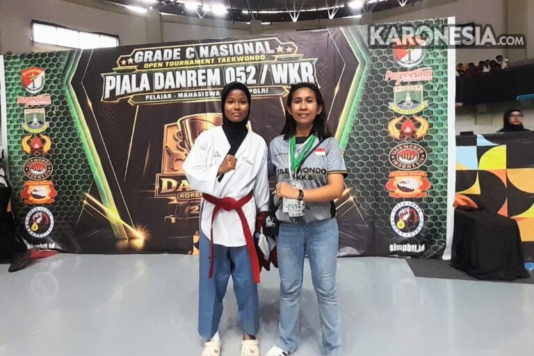 Pelatih Derina Da Cunha bersama atlet di depan backdrop Kejuaraan Danrem 052 Wijayakrama