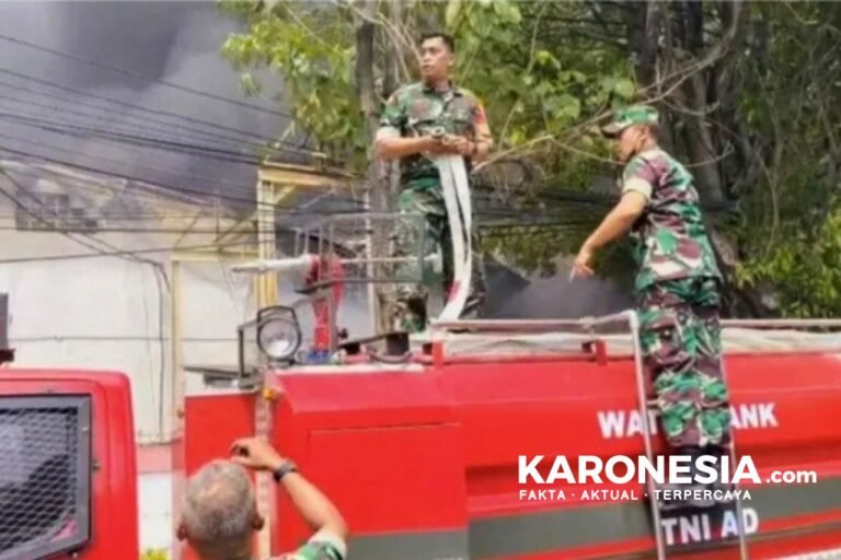 Personel TNI Koramil Batuceper menyiapkan selang air di atas mobil water tank saat pemadaman kebakaran.