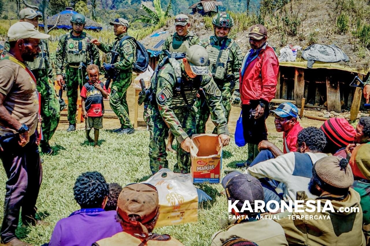 Prajurit TNI menyerahkan bantuan sembako kepada warga Ugimba.
