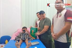 Perwira Kodim 0203 Langkat menyerahkan bingkisan kepada anak peserta sunatan massal saat Baksos Kesehatan HUT ke-81 TNI