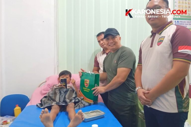 Perwira Kodim 0203 Langkat menyerahkan bingkisan kepada anak peserta sunatan massal saat Baksos Kesehatan HUT ke-81 TNI