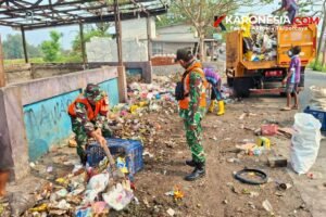 Personel Babinsa Koramil 09/Mauk bersama petugas DLH memilah dan mengangkut sampah ke dalam truk di Jalan Raya Tanjung Kait.