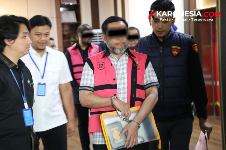 Tersangka korupsi MBG di BGN berompi pink dan diborgol dikawal petugas saat penyerahan tahap II ke Kejari Jakarta Pusat