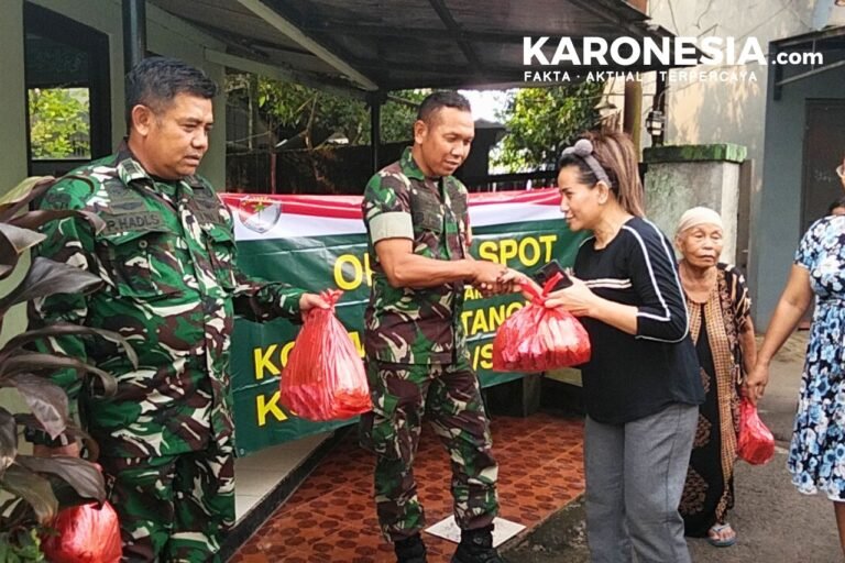 Dua personel TNI menyerahkan paket sembako kepada warga di Kampung Jeletreng, Tangerang Selatan