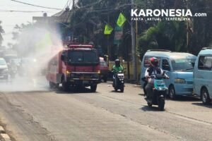 Personel Koramil 02/Pondok Gede menyemprot jalan menggunakan kendaraan water tank untuk mengatasi debu abu vulkanik di Kota Bekasi.