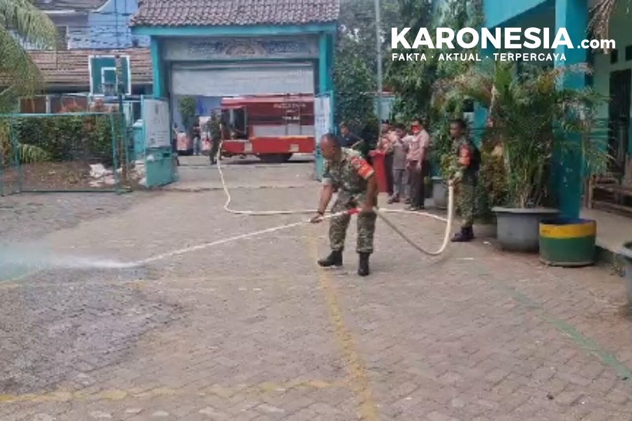Penyemprotan lapangan SMA BINS terdampak abu vulkanik