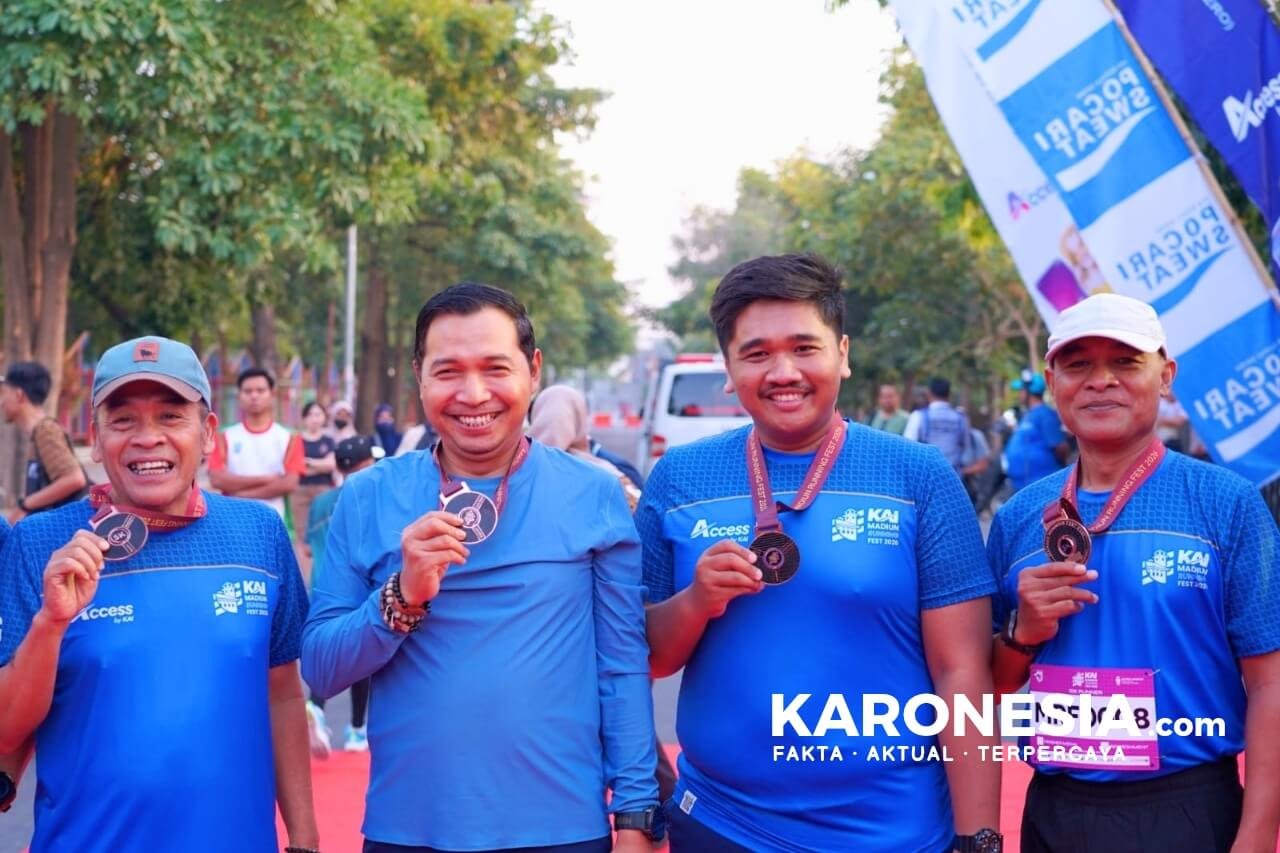 Peserta menunjukkan medali di KAI Madiun Running Fest 2026.